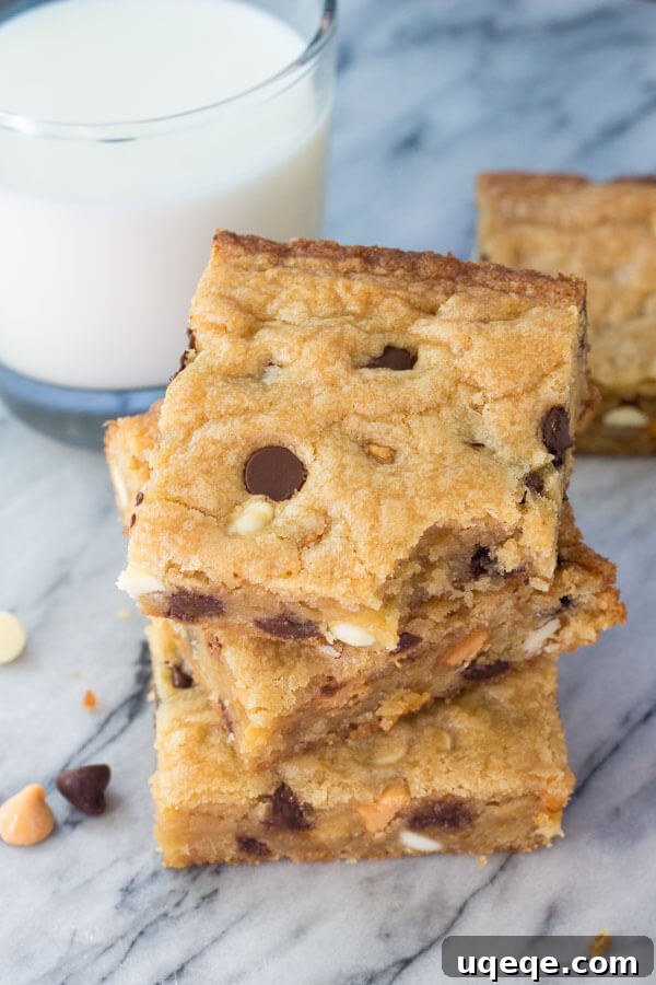 Triple Chocolate Chip Dream Bars 4 Overhead shot of 3 triple chip cookie bars stacked. Glass of milk in the background.