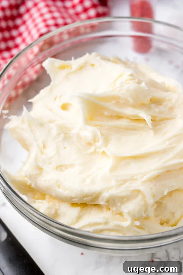 Effortless Red Velvet Delight 5 A bowl of cream cheese frosting for decorating red velvet cake.