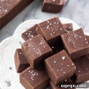 Effortless Homemade Fudge 6 A circular image of a piece of easy chocolate fudge with some nuts on top.