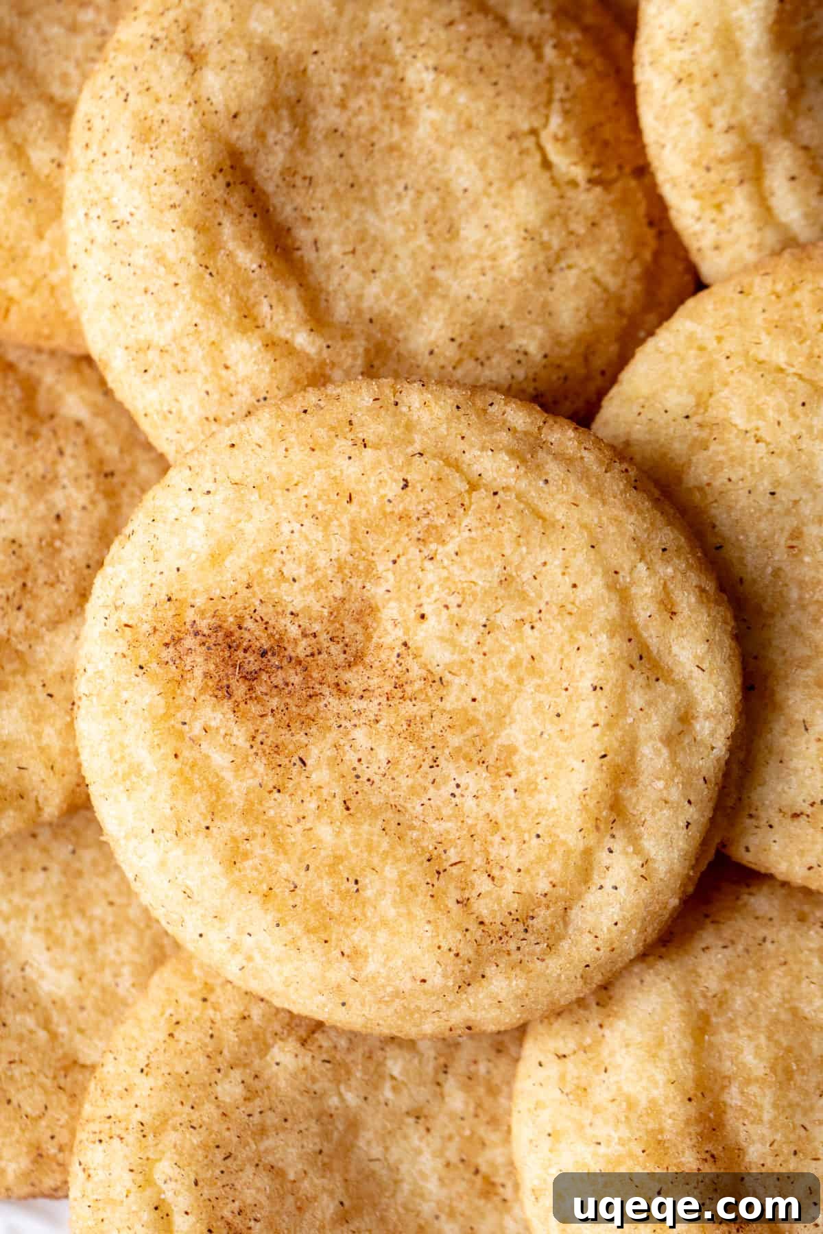 Perfectly Chewy Snickerdoodle Cookies 3 Snickerdoodle cookies, piled on top of each other, showcasing their soft texture and cinnamon sugar coating