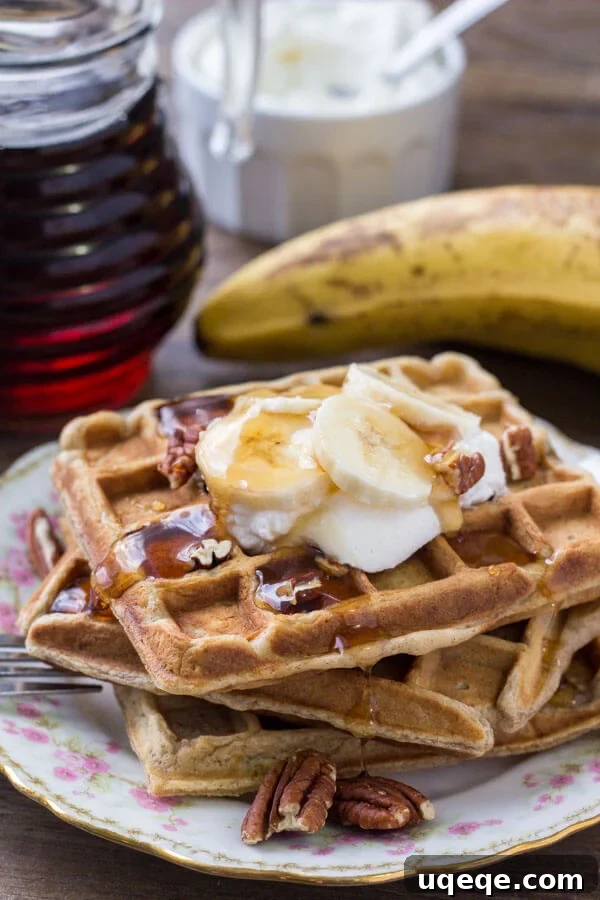 Banana Bread Bliss Waffles: Fluffy, Fragrant, and Cinnamony 4 A beautiful stack of golden banana bread waffles, generously drizzled with maple syrup and garnished with fresh whipped cream, sliced bananas, and crunchy pecans.