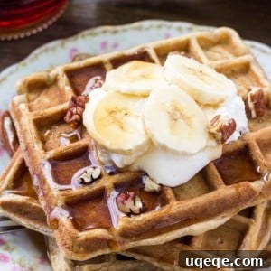 A beautifully presented stack of fluffy banana bread waffles, topped with fresh fruit and syrup, perfect for a delightful meal.