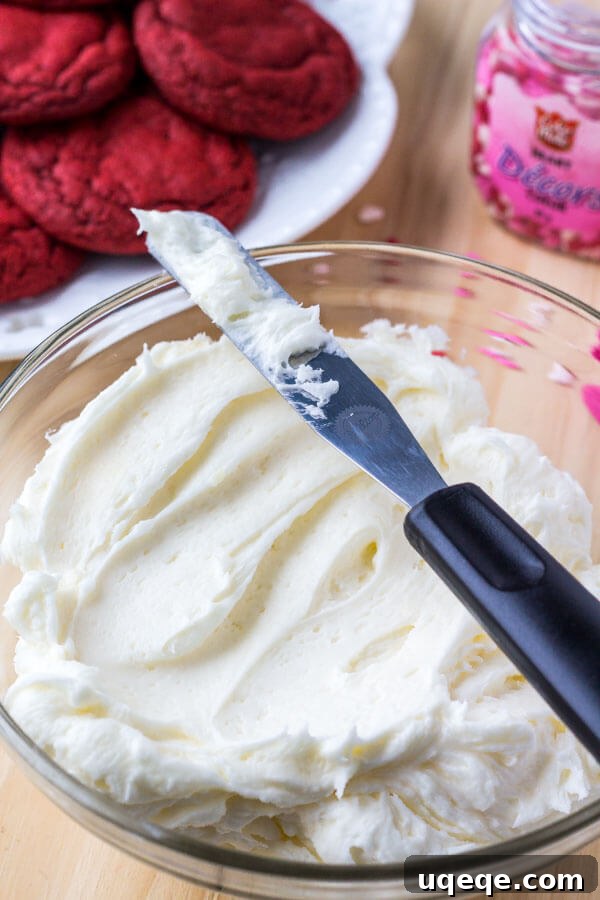 Velvet Crimson Delights 4 A bowl of fluffy, white cream cheese buttercream frosting, perfectly whipped and ready to be spread onto the red velvet cookies.