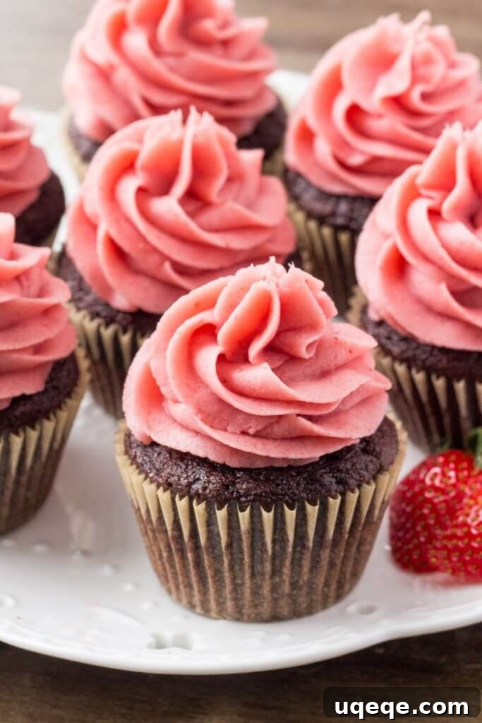 Berry Kissed Chocolate Cupcakes 4 Moist chocolate cupcakes adorned with luscious strawberry buttercream frosting, evoking the delight of chocolate-covered strawberries.