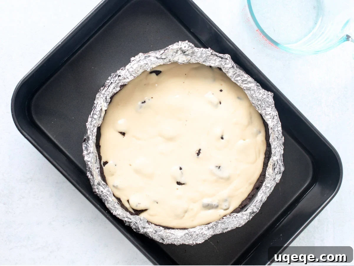 Oreo Obsession Cheesecake 6 Unbaked Oreo cheesecake in a water bath.