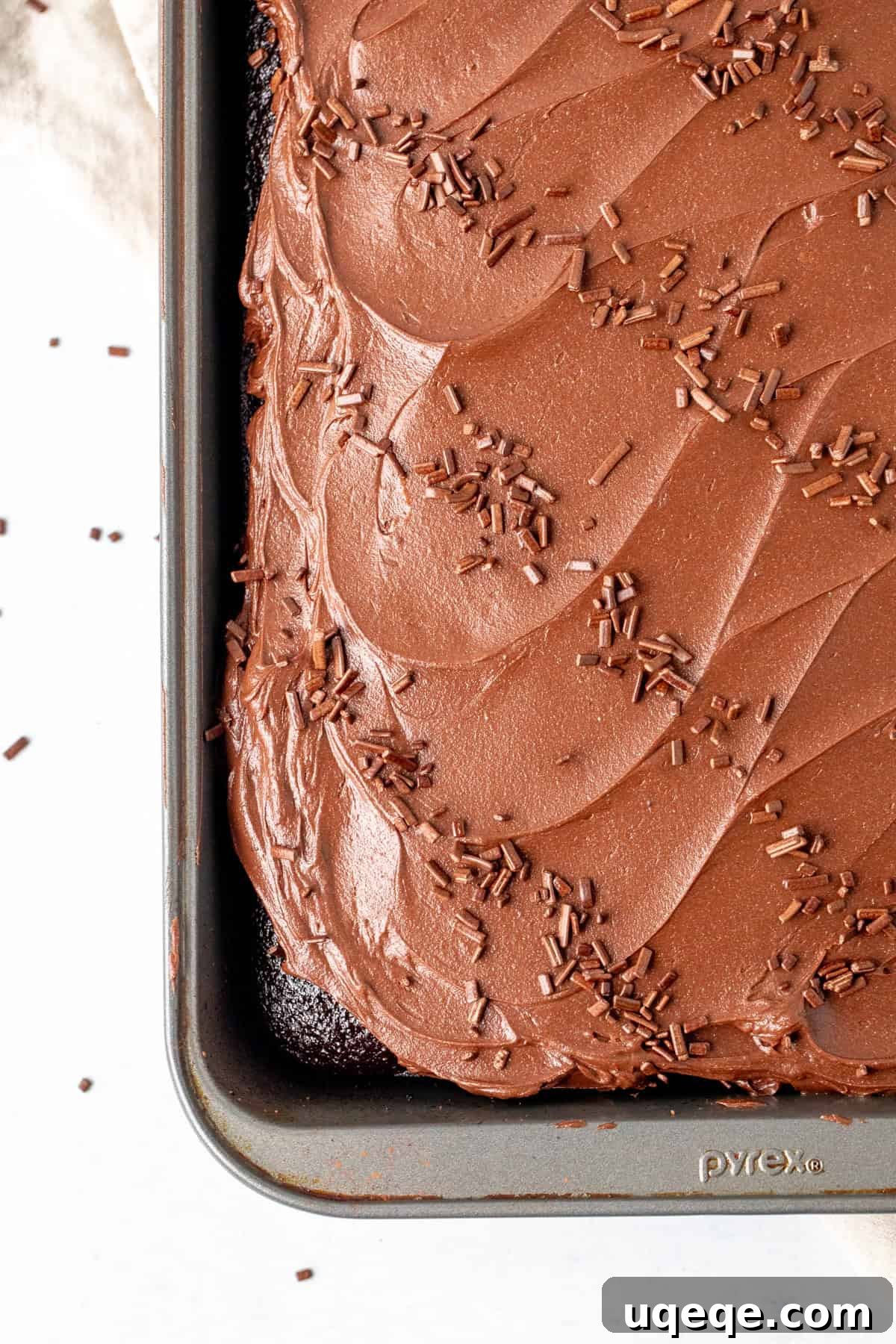 Rich & Easy Chocolate Cake 5 A freshly baked chocolate sheet cake in a 9x13 inch pan, beautifully topped with a generous layer of creamy chocolate frosting.