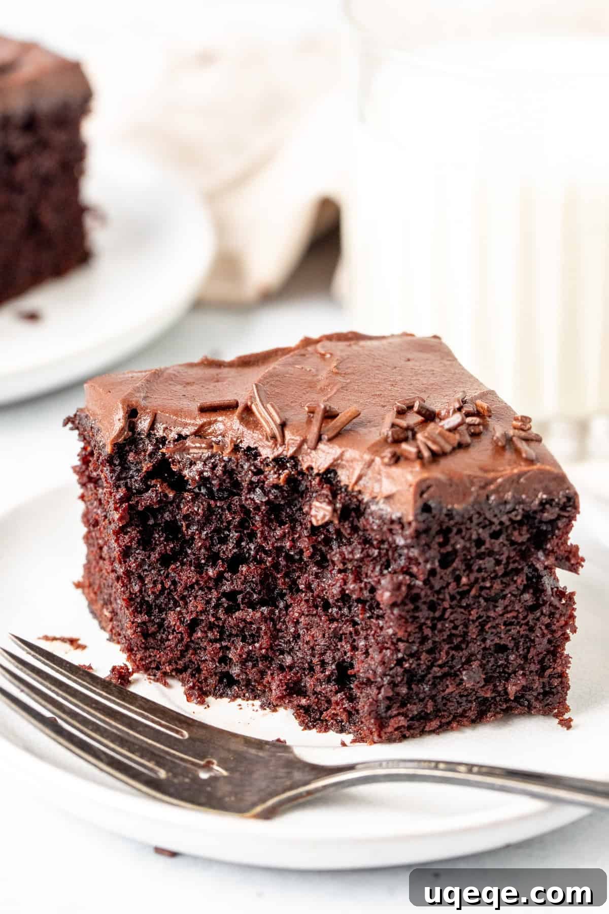 Rich & Easy Chocolate Cake 6 A delicious slice of chocolate sheet cake with a bite taken out, showcasing its moist interior and creamy frosting.