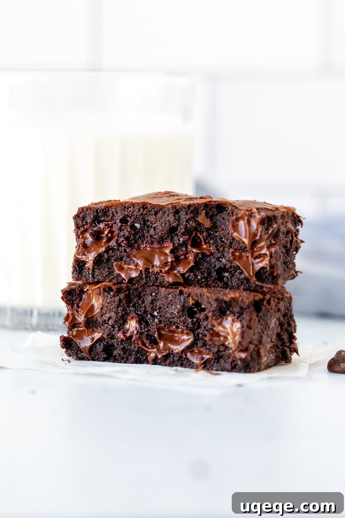 Chocoholic's Dream Brownies 4 A triple chocolate fudge brownie broken in half, revealing gooey melted chocolate chips inside.
