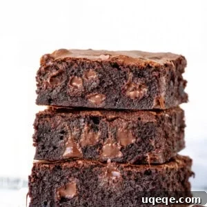 Stack of three gooey brownies with melted chocolate chips, representing the triple chocolate brownies recipe