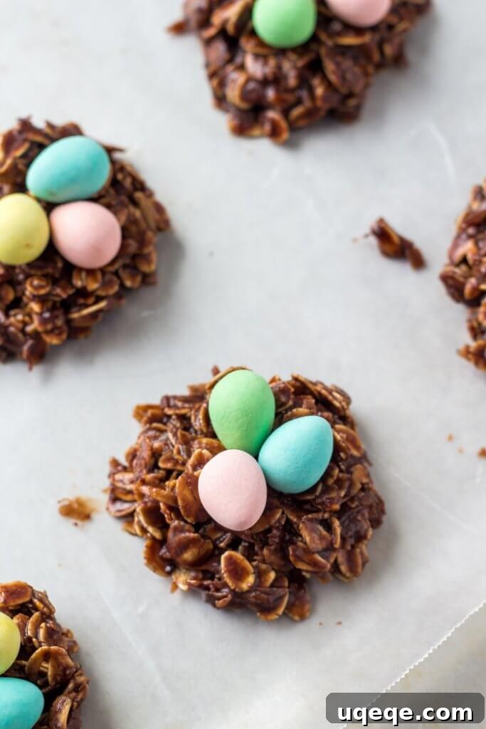 Sweet Spring Nests 3 No Bake Chocolate Oatmeal Easter Nests with mini eggs on parchment paper.