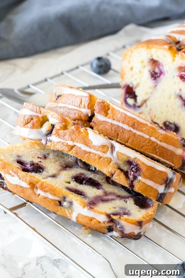 Close-up shot of the glazed blueberry bread, highlighting its golden-brown top and the luscious glaze.