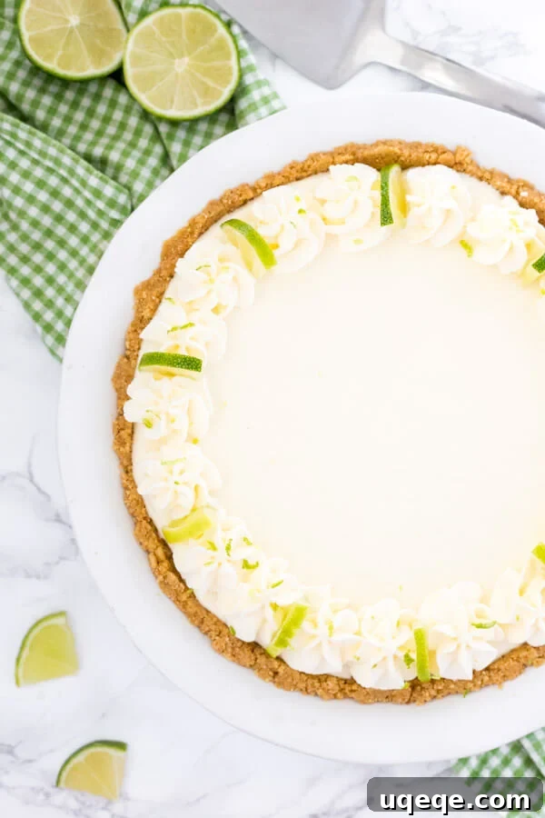Effortless Key Lime Bliss 3 Overhead view of an entire no bake key lime pie with whipped cream and lime slices to decorate.