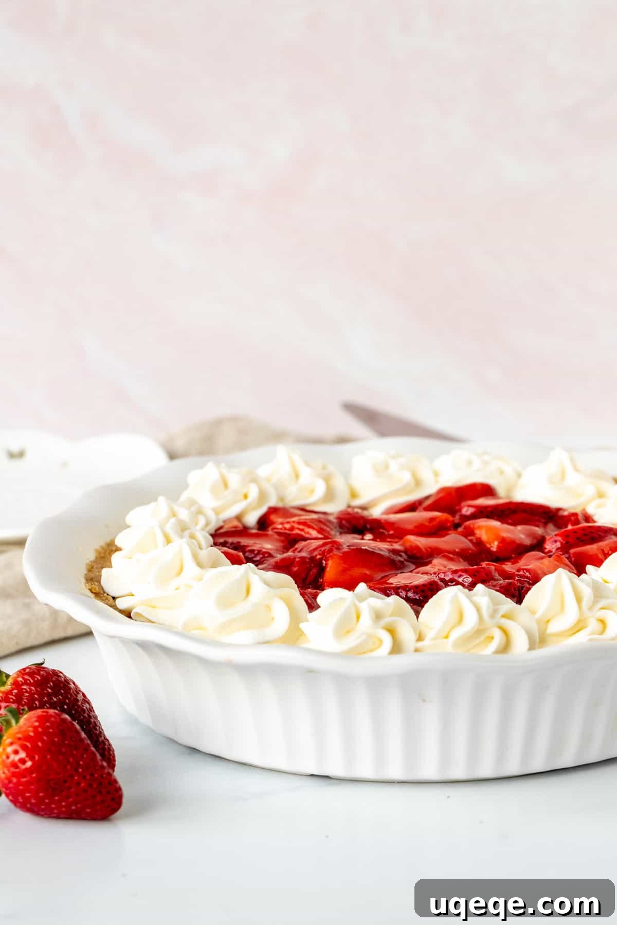 Strawberry Dream Cheesecake 2 Strawberry cream cheese pie topped with whipped cream in a white pie plate