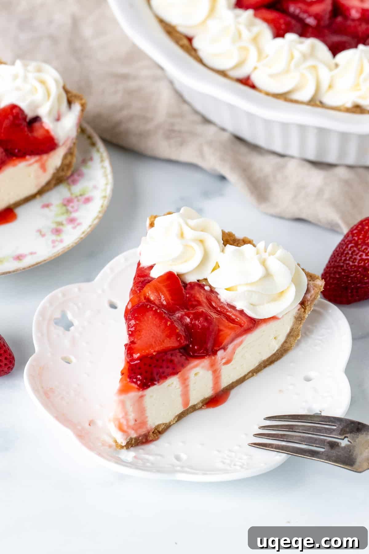 Strawberry Dream Cheesecake 3 Slice of strawberry cheesecake pie with whipped cream on top