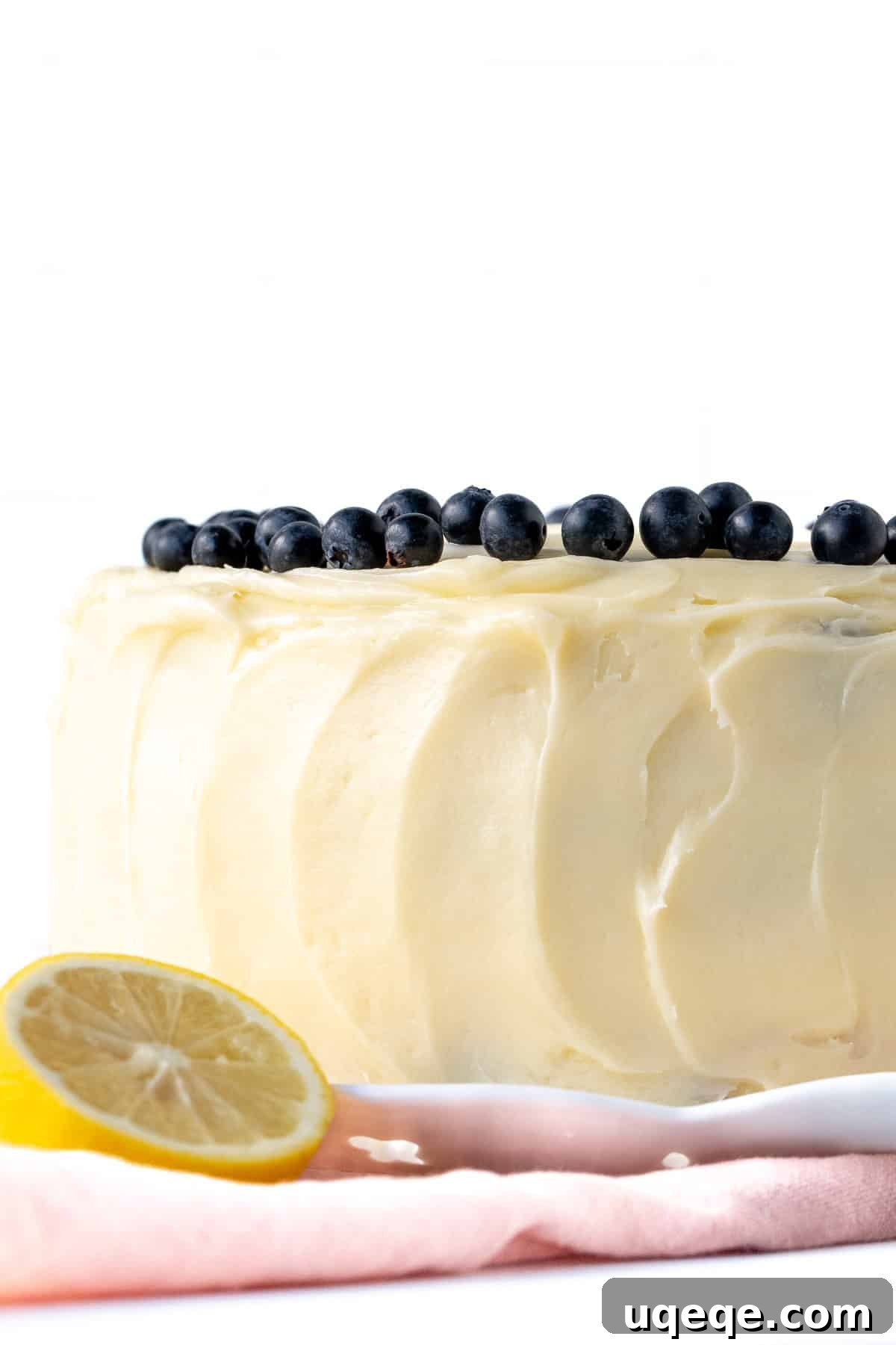 Sunshine Lemon Blueberry Cake 8 An elegantly frosted 8-inch round lemon blueberry layer cake, beautifully decorated with fresh blueberries on top, ready to be served.
