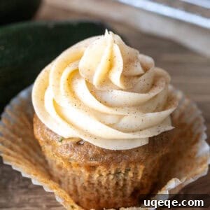 Zucchini cupcake with cream cheese frosting swirled on top, ready for serving.