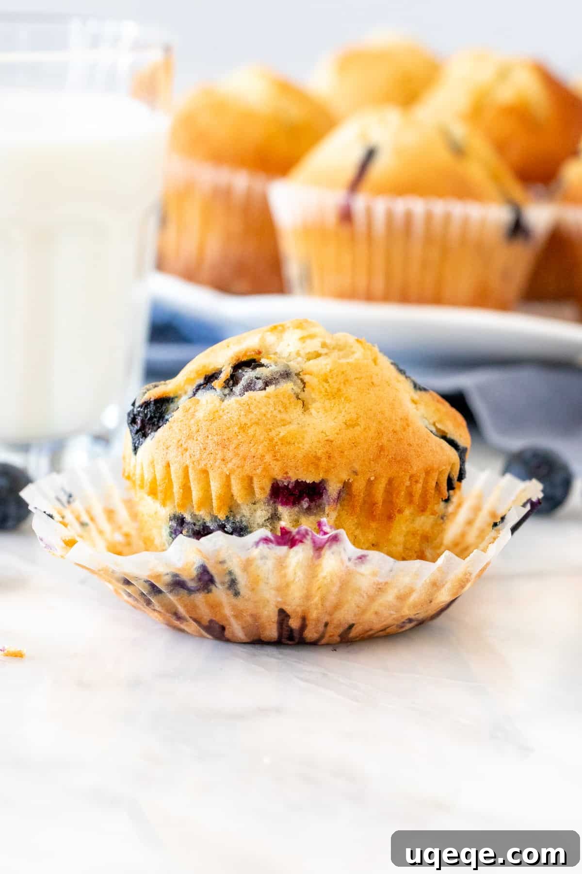 Bake Irresistible Blueberry Muffins Fast 2 Blueberry muffin with a glass of milk, highlighting the fluffy texture and golden top