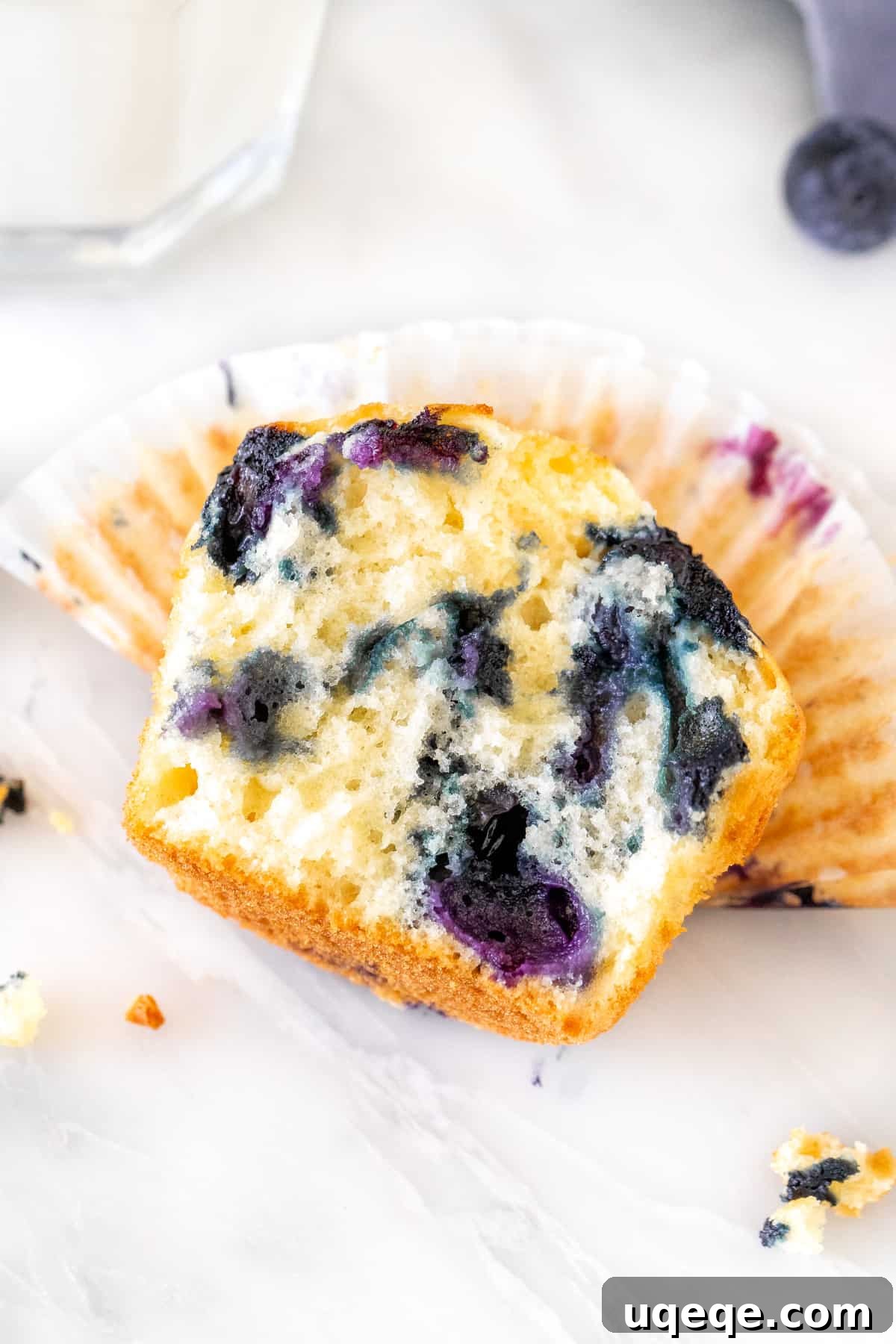 Bake Irresistible Blueberry Muffins Fast 5 Half of a blueberry muffin showing the moist interior and blueberries