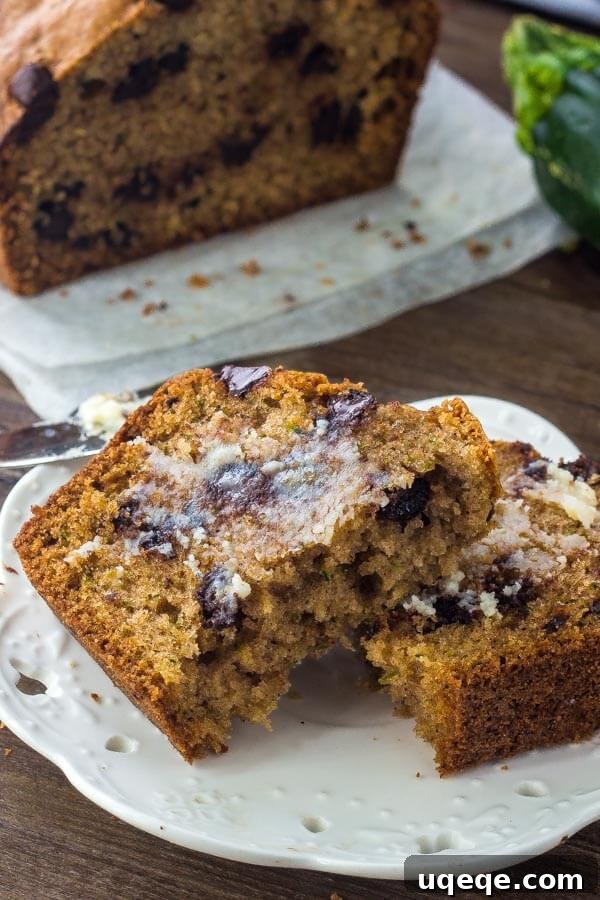 Decadent Chocolate Chip Zucchini Loaf 6 A thick slice of chocolate zucchini bread showing off its moist crumb and abundant chocolate chips, ready to be enjoyed.