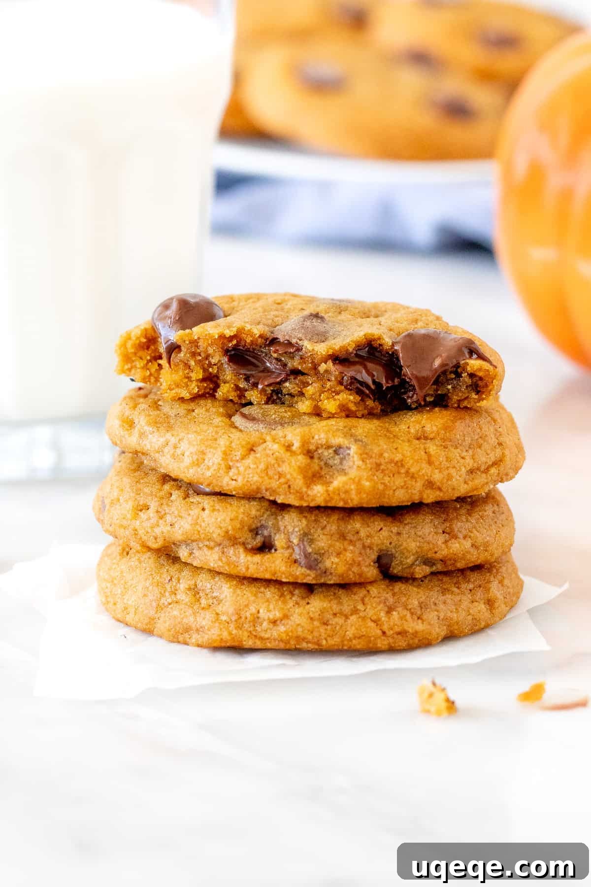 Soft-Baked Pumpkin Chocolate Chip Delights 6 A charming stack of pumpkin chocolate chip cookies alongside a refreshing glass of milk, inviting enjoyment.