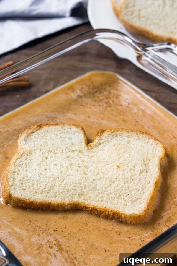 Golden Pumpkin Spice French Toast 4 Bread being dunked in pumpkin French toast batter to show how to make it.