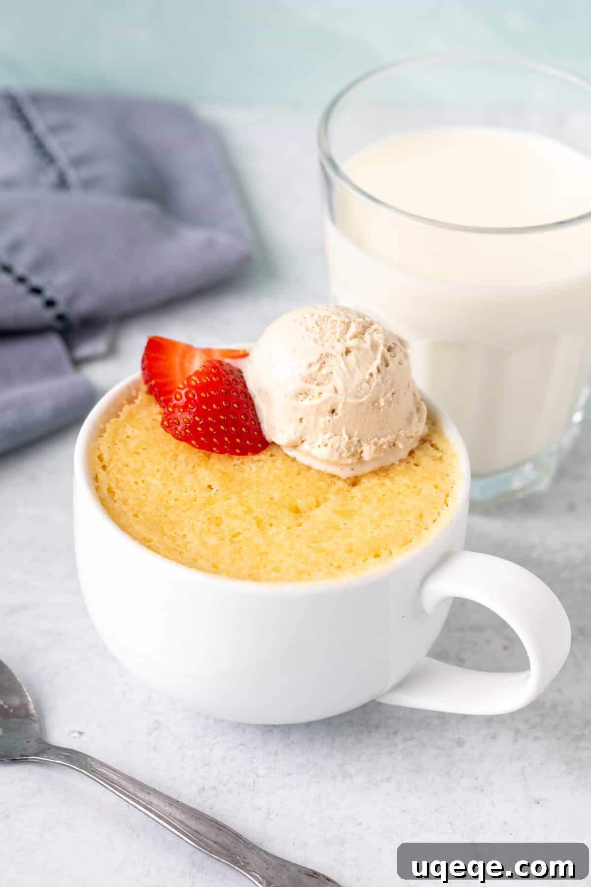 Easy Vanilla Mug Cake 3 Moist vanilla mug cake topped with a scoop of ice cream and strawberies