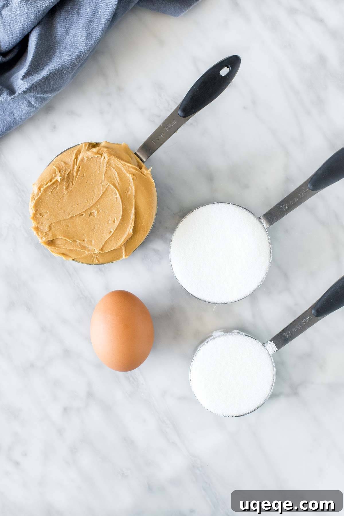 Effortless 3 Ingredient Peanut Butter Cookies 3 Peanut butter, white sugar and 1 egg - ingredients measured out for making peanut butter cookies.