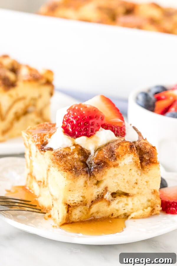 Overnight French Toast Bake 2 Slice of French toast casserole on a plate, topped with cream, berries and syrup. A perfect make-ahead breakfast or brunch dish.