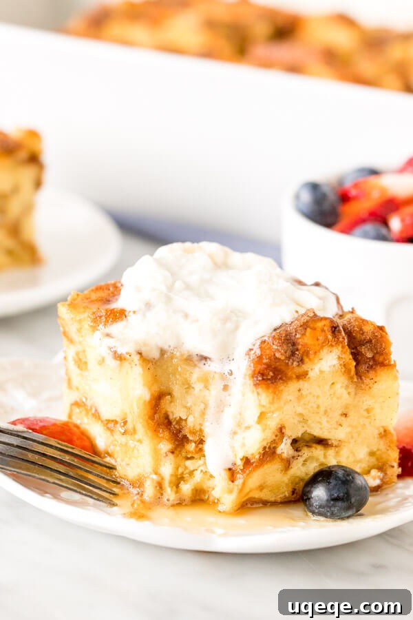 Overnight French Toast Bake 6 Square slice of french toast casserole with whipped cream on top and a bite taken out of it. A hearty and satisfying breakfast.
