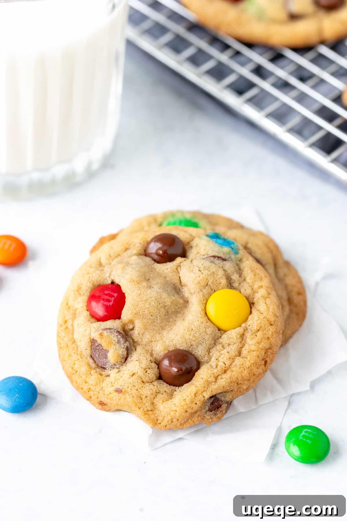 Irresistibly Soft Chewy M and M Cookies 2 Two M&M cookies with a glass of milk, highlighting their soft texture and vibrant colors