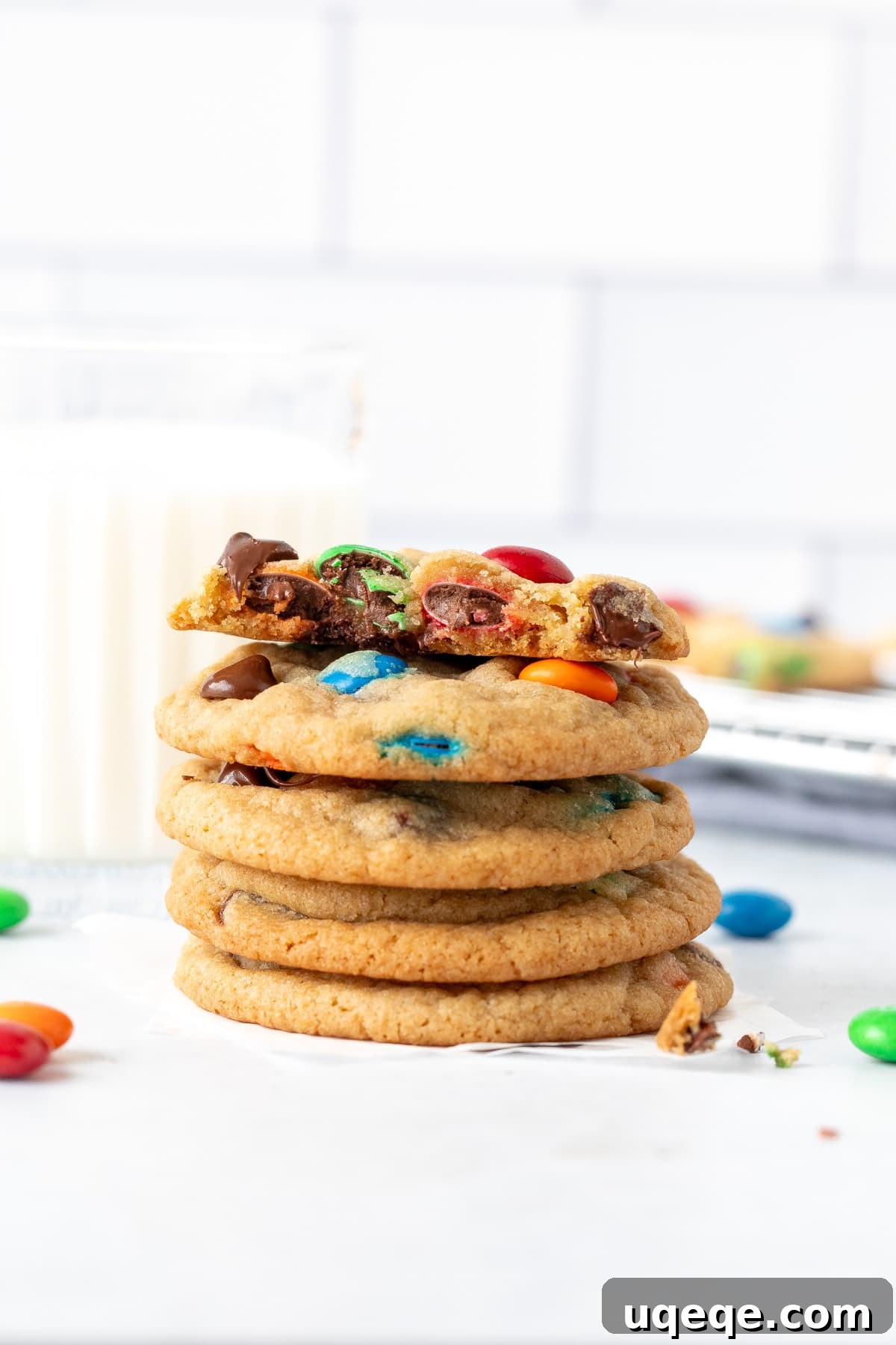 Irresistibly Soft Chewy M and M Cookies 8 A stack of M&M chocolate chip cookies accompanied by a glass of milk, emphasizing their deliciousness and a perfect treat.
