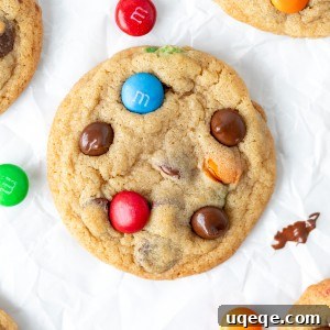 M&M chocolate chip cookies on baking paper, showcasing their vibrant colors and perfect round shape.