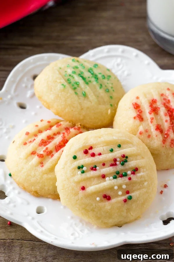 A plate of fluffy whipped shortbread cookies adorned with festive holiday sprinkles, ready to be enjoyed.