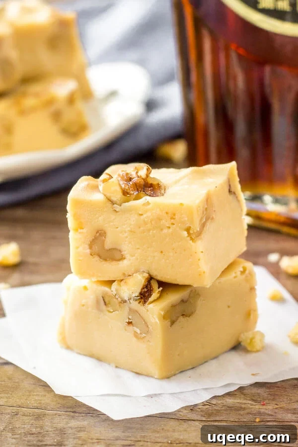 Golden Maple Walnut Delight 2 Easy maple walnut fudge is extra creamy and made with only 4 ingredients. A close-up shot of a square of fudge with walnuts visible.