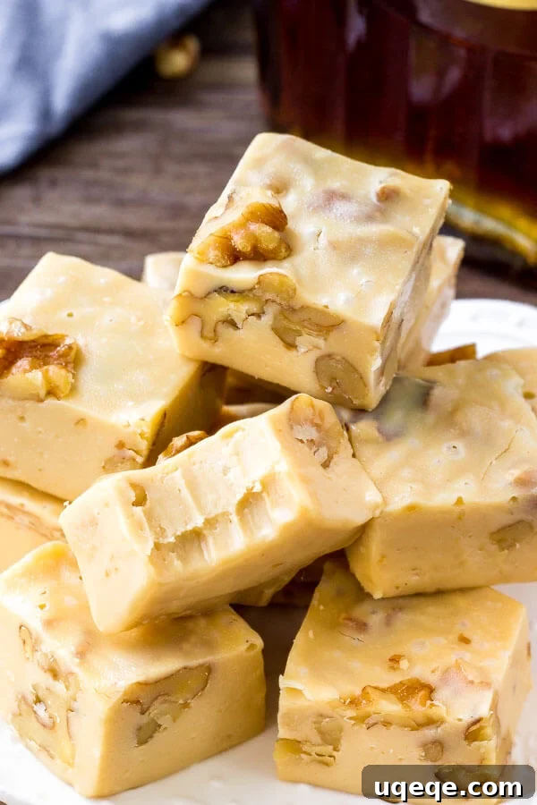 Golden Maple Walnut Delight 5 Easy maple fudge recipe - filled with walnuts and perfect for the holidays. A close-up of a hand holding a piece of fudge.