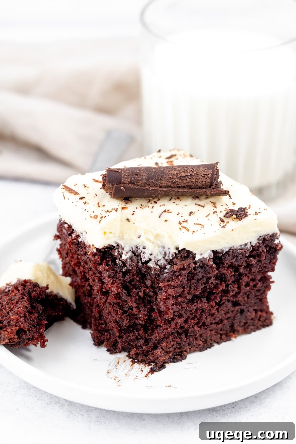 Velvet Chocolate, Cloud-White Topping 3 Square piece of chocolate cake sheet cake with white chocolate frosting with a bite taken out