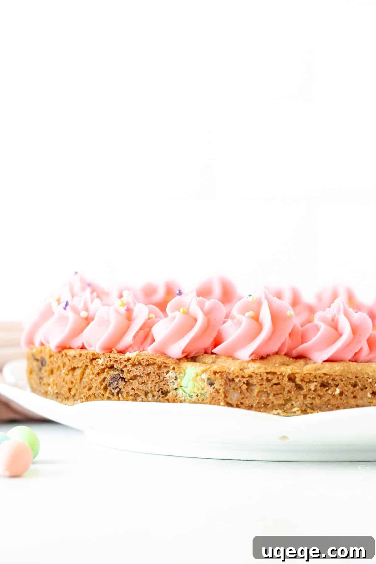 Easter Cookie Cake Delight 5 A beautifully decorated Easter cookie cake, studded with chocolate Easter eggs and a delicate vanilla frosting border.