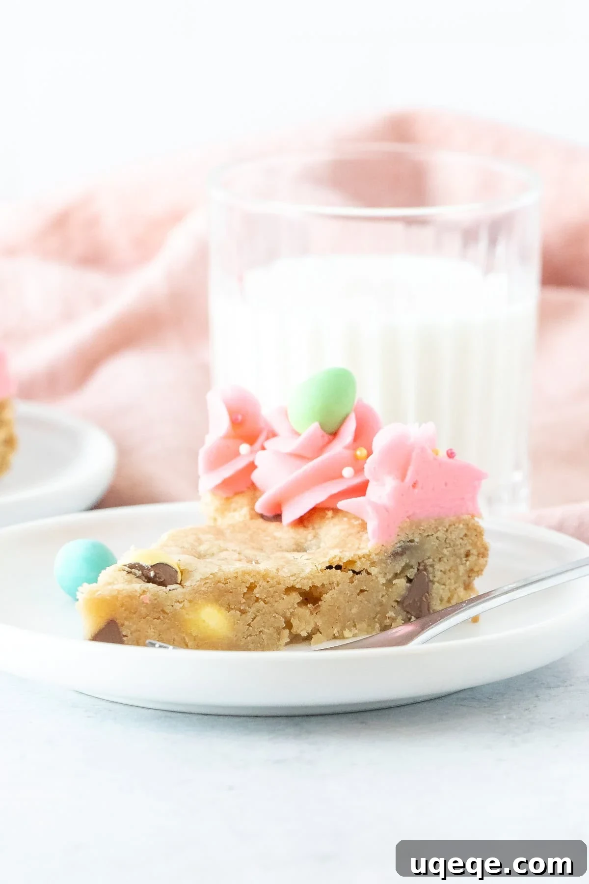 Easter Cookie Cake Delight 6 A delectable slice of Easter cookie cake, adorned with pink frosting, ready to be served and savored.