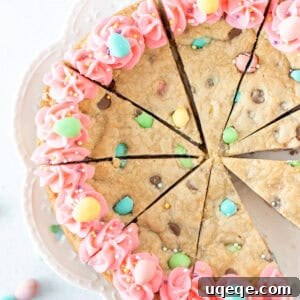 Easter cookie cake decorated with pink frosting, cut into slices