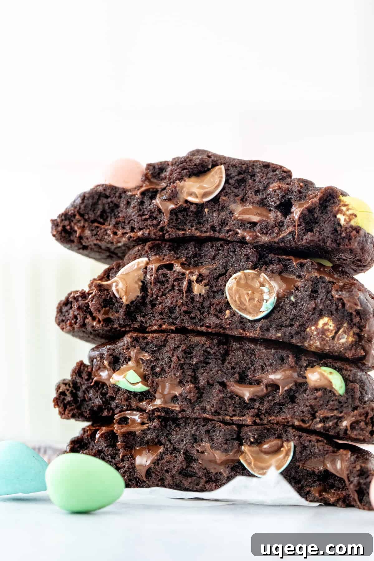 Delightful Mini Egg Chocolate Cookies 3 Chocolate cookies with Easter Candies, broken in half and stacked on top of one another, showcasing rich texture