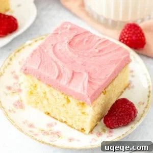 Slice of almond cake with raspberry frosting with a glass of milk