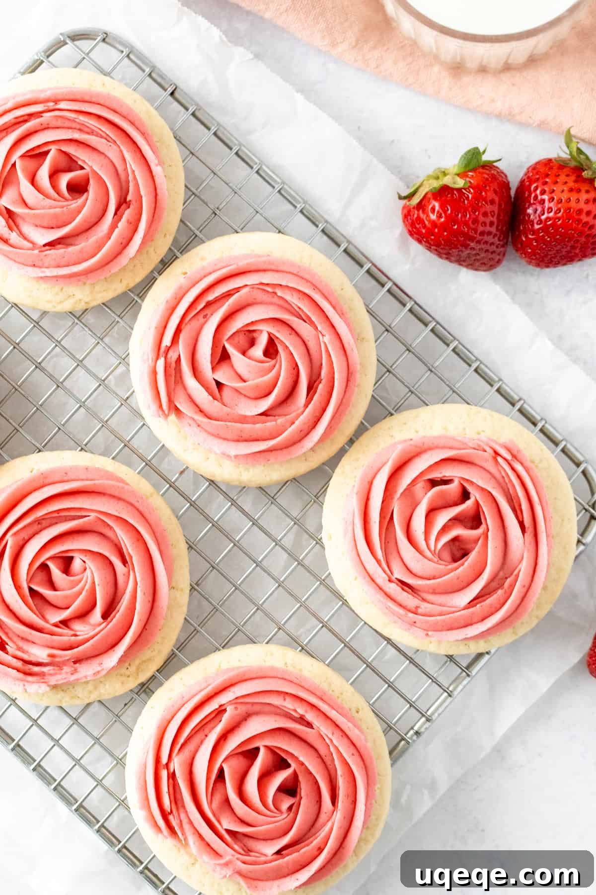 Strawberry Frosted Sugar Cookies Recipe — Soft, Iced Treats 4 Sugar cookies with strawberry frosting on a cooling rack