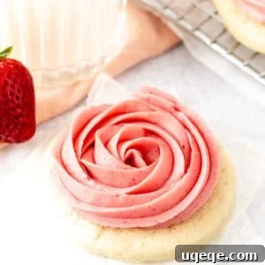 Strawberry Frosted Sugar Cookies Recipe — Soft, Iced Treats 6 Sugar cookie topped with strawberry frosting piped into a rosette shape