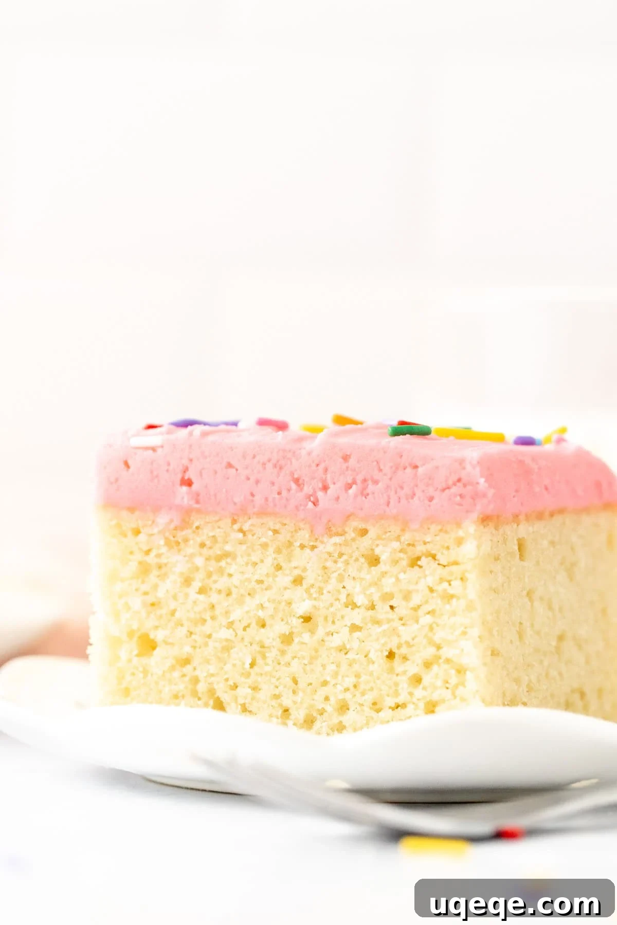 Classic Vanilla Sheet Cake Recipe for Moist, Crowd-Pleasing Dessert 9 Slice of vanilla sheet cake with pink vanilla frosting