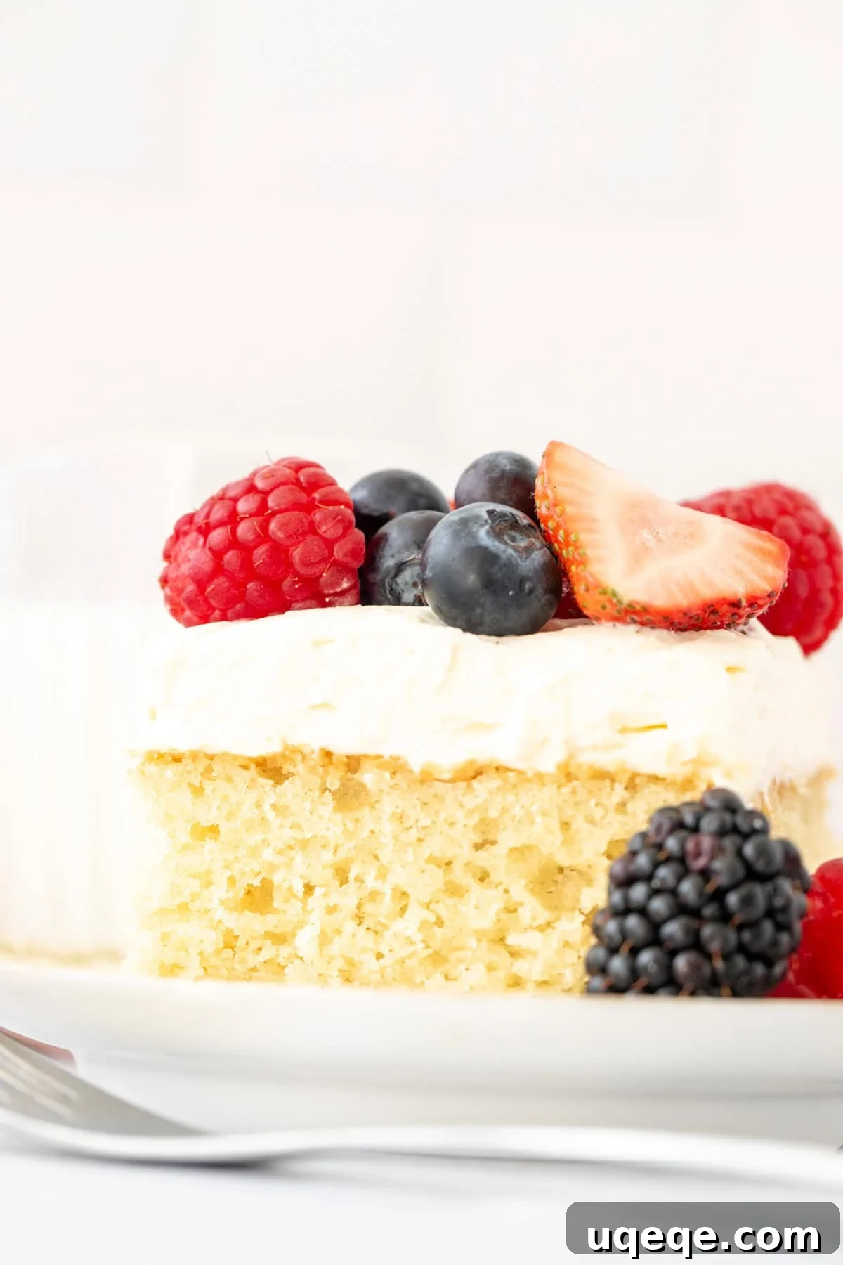 Berries and Cream Sheet Cake Recipe — Light Berry Dessert for Gatherings 4 Slice of vanilla cake with whipped cream and fresh berries on top