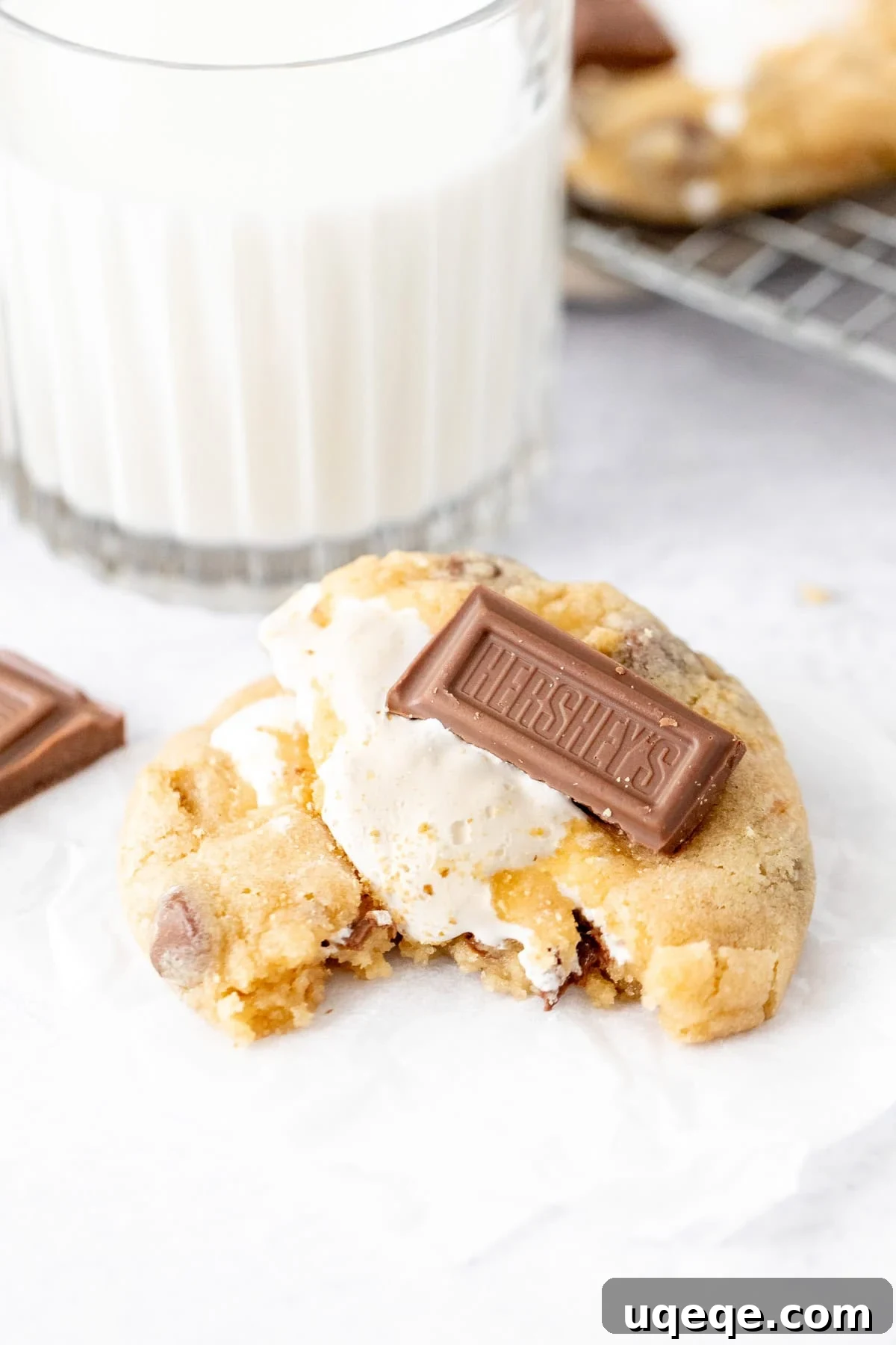 Gooey S'mores Cookies with Chocolate & Toasted Marshmallow 7 S'mores stuffed cookie, broken in half with a glass of milk