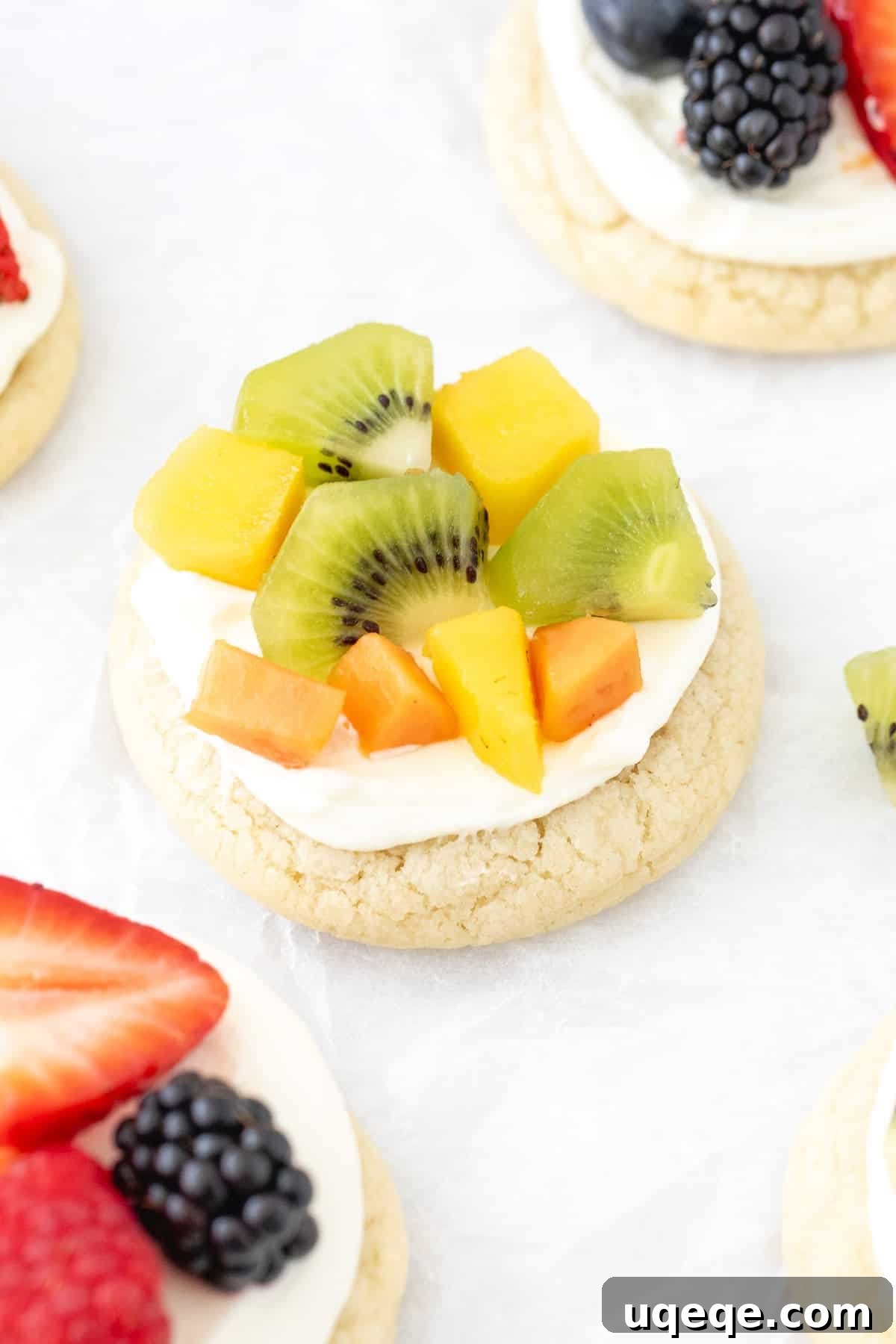 Mini Fruit Pizza Bites with Cream Cheese Frosting 3 Mini fruit pizza with cream cheese frosting and tropical fruit on top
