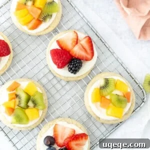 Mini Fruit Pizza Bites with Cream Cheese Frosting 7 mini fruit pizzas on a wire rack