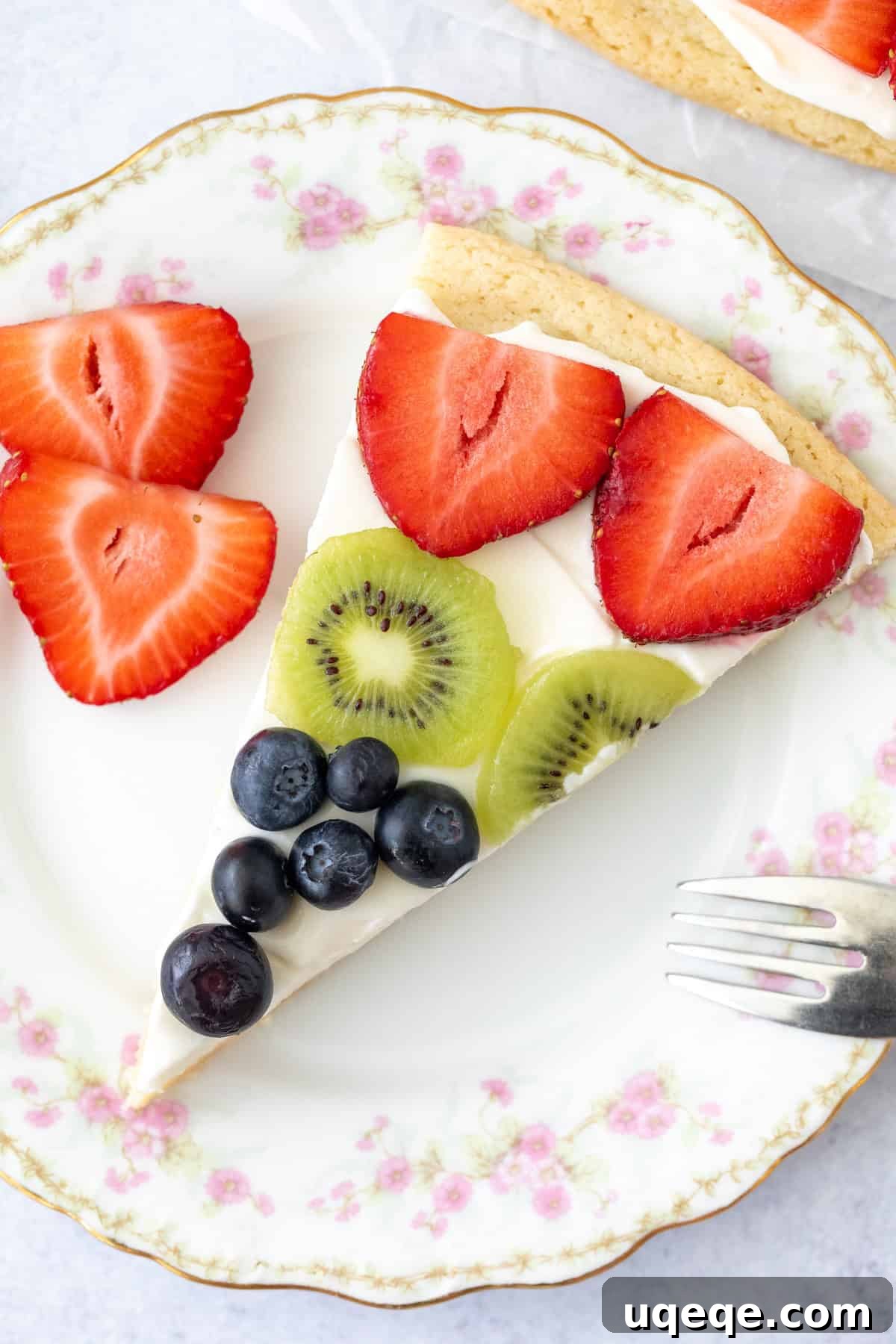 No-Bake Fruit Pizza with Cream Cheese Frosting 5 Slice of sugar cookie fruit pizza on a plate