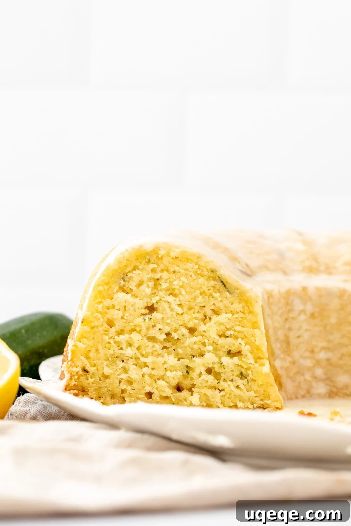 Moist Lemon Zucchini Cake with Cream Cheese Glaze 9 Lemon zucchini bundt cake on a white plate with slices cut out